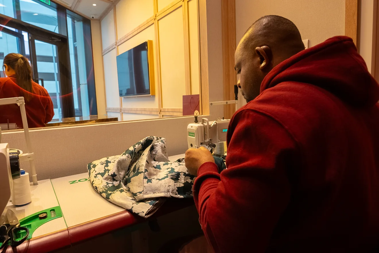 A tailor at work inside a Tailor Express branch.